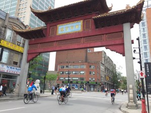 Cyclists riding through red gate Montreal's Chinatown