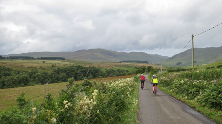 Two cyclist on the road to Scottish highlands
