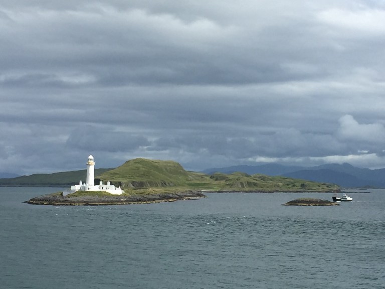 white lighthouse and fishing boat scotland